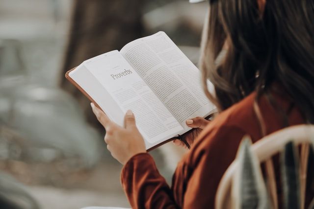 A girl is reading a book in a quiet place.